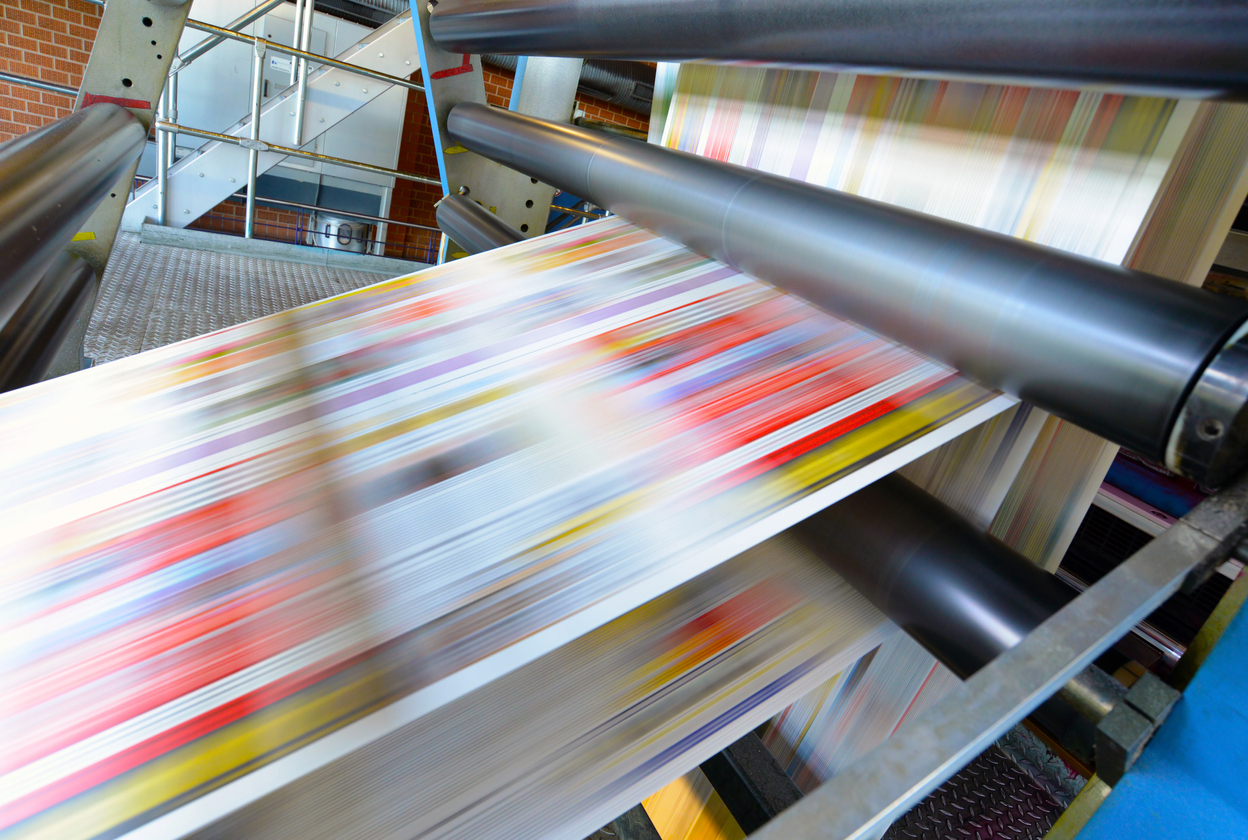 colorful paper rushing past on a printing press